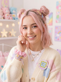 Model wearing pastel Tamagotchi pin brooch on cream cardigan lapel