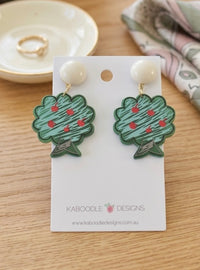 Acrylic apple tree drop earrings with cream button top, laid on Kaboodle Designs card