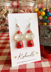 Red and clear resin gumball machine earrings on card, showing rainbow sprinkle detail inside the dome