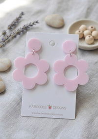 Pastel pink acrylic daisy drop earrings on a Kaboodle Designs card, flat view