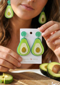Woman wearing green avocado perspex earrings with gold glitter centre, close-up