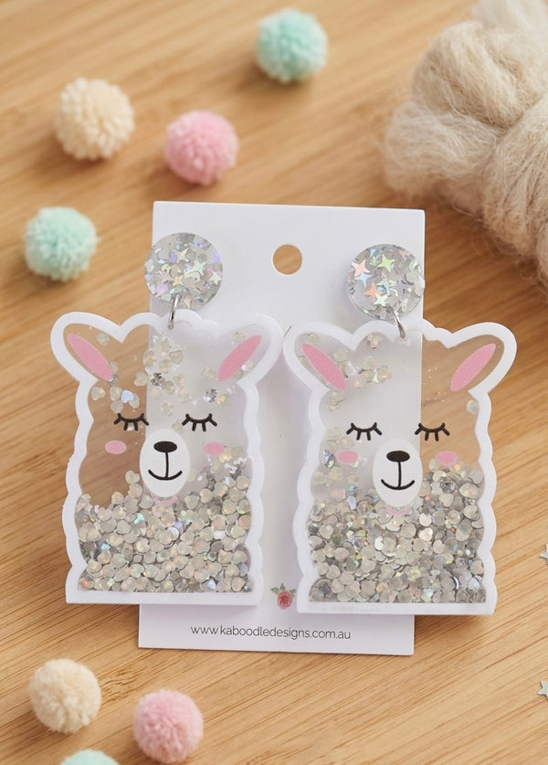 Acrylic llama face drop earrings with silver glitter shaker detail on card backing