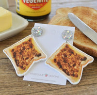 Pair of acrylic Vegemite toast drop earrings with glitter star studs, shown with a real jar of Vegemite and toast