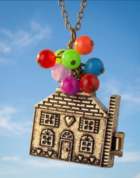 Bronze-tone house locket pendant with cluster of colourful balloon beads on chain, against blue sky