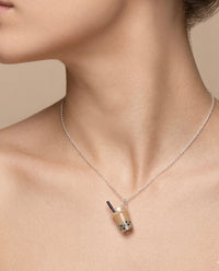 Boba milk tea pendant necklace worn on model's neck, close-up on collarbone