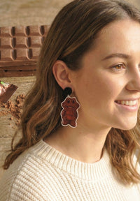 Chocolate frog dangle earring worn on model's ear, side profile view