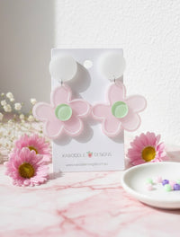 Pink acrylic daisy flower drop earrings with mint green centres on a Kaboodle Designs card