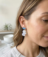 Astronaut bear earring worn on ear, close-up side view showing bow stud detail
