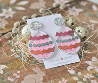 Easter egg glitter earrings displayed on card nestled among quail eggs and straw