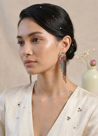 Model wearing a rhinestone parrot drop earring, side profile view showing length against the neck
