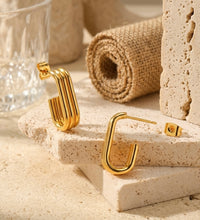 Pair of ribbed gold hoop earrings shown open with butterfly backing detached