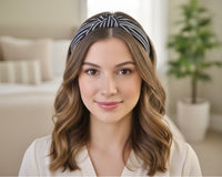 Woman wearing black and white striped knotted headband, front view