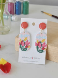 Tulip print acrylic drop earrings with coral stud tops on a Kaboodle Designs card