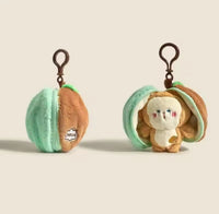 Two views of mint and tan plush pouch keychain, zipped closed and open showing monkey plush inside