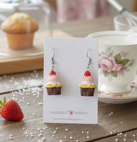 Resin strawberry cupcake drop earrings on a Kaboodle Designs card, styled with a teacup and muffin