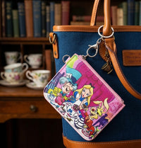Alice in Wonderland coin purse keychain clipped to handbag strap, tea party design visible