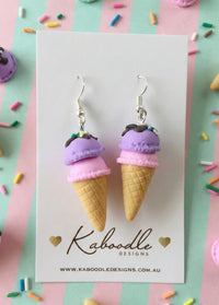Pink and purple double-scoop ice cream cone earrings on Kaboodle Designs card with sprinkle background
