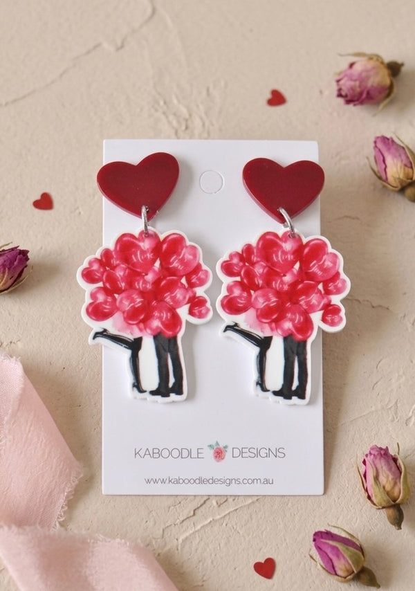 Pair of rose bouquet drop earrings with red heart studs displayed on Kaboodle Designs card