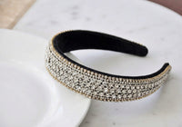 Close-up of wide rhinestone headband showing dense diamante rows and black velvet underside