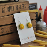 Two resin cheeseburger drop earrings on a card, showing sesame bun and lettuce detail