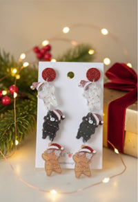 Three-tier acrylic cat earrings on card, cats in santa hats with fairy lights among Christmas decor