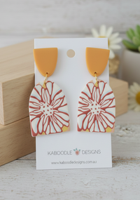 Orange and cream geometric flower drop earrings on Kaboodle Designs card