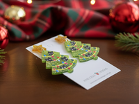 Close-up angled view of Christmas tree cat earrings showing glitter finish and coloured light details