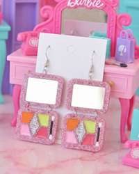 Pink glitter acrylic makeup palette earrings with mirror top and eyeshadow pans on card, styled on Barbie vanity