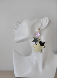 Star drop earring shown worn on model, close-up side view of graduating star sizes