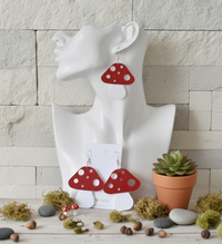 Single mushroom drop earring worn on a white display bust, red spotted cap and white stem