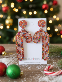 Confetti perspex candy cane drop earrings with round stud tops on Kaboodle card, Christmas tree background