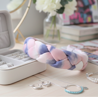 Braided headband resting beside a jewellery case, earrings, necklace and bracelet