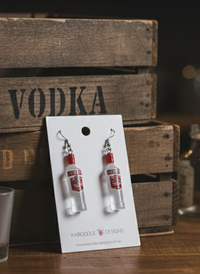 Resin vodka bottle drop earrings with red cap and label, on Kaboodle Designs card