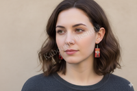 Model wearing red Pocky box drop earrings, side profile close-up