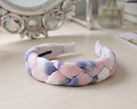 Braided cotton candy coloured headband laid flat on a wooden surface