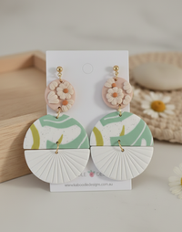 Clay drop earrings with blush floral top disc, sage patterned middle and white fan bottom tier