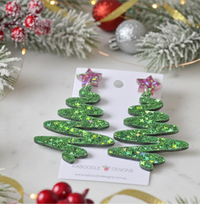 Close-up angled view of green sparkle Christmas tree earrings showing star topper detail