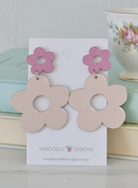 Pink mirrored flower drop earrings on a Kaboodle Designs card, styled with a floral teacup