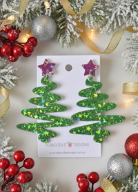 Green glitter Christmas tree swirl drop earrings with pink star studs on backing card