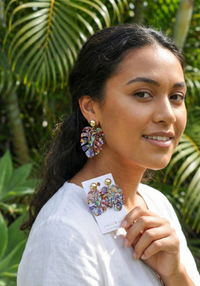 Woman wearing multicolour monstera leaf drop earring, close-up on ear
