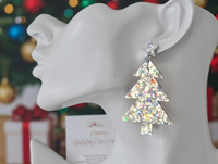 Close-up side view of glitter Christmas tree earring worn on ear, showing star stud and layered tree shape