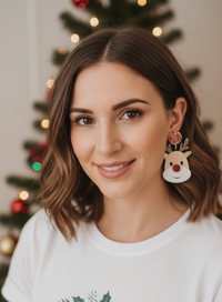 Close-up of a woman wearing a glittery reindeer drop earring with confetti top stud