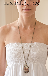 Model wearing the vintage-style pendant necklace on a long chain for size reference