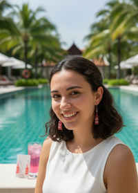 Woman by a pool wearing red bottle-shaped novelty drop earrings