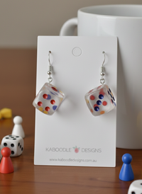 Clear acrylic dice dangle earrings with red, blue and yellow dots on a Kaboodle card
