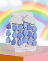 White cloud and blue raindrop perspex dangle earrings on Kaboodle Designs card, rainbow background