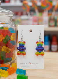 Rainbow gummy bear resin drop earrings displayed on a Kaboodle Designs card with lolly jars in background