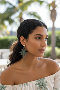 Palm tree shaker earring worn on model's ear, side profile view