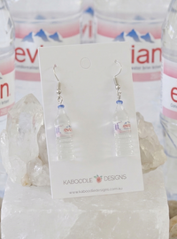 Pair of clear resin Evian water bottle drop earrings on a Kaboodle Designs card, styled with crystals