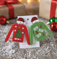 Mismatched acrylic Christmas jumper earrings, one red with glitter tree, one green with 'Ho Ho Ho' text, both with Santa hat
